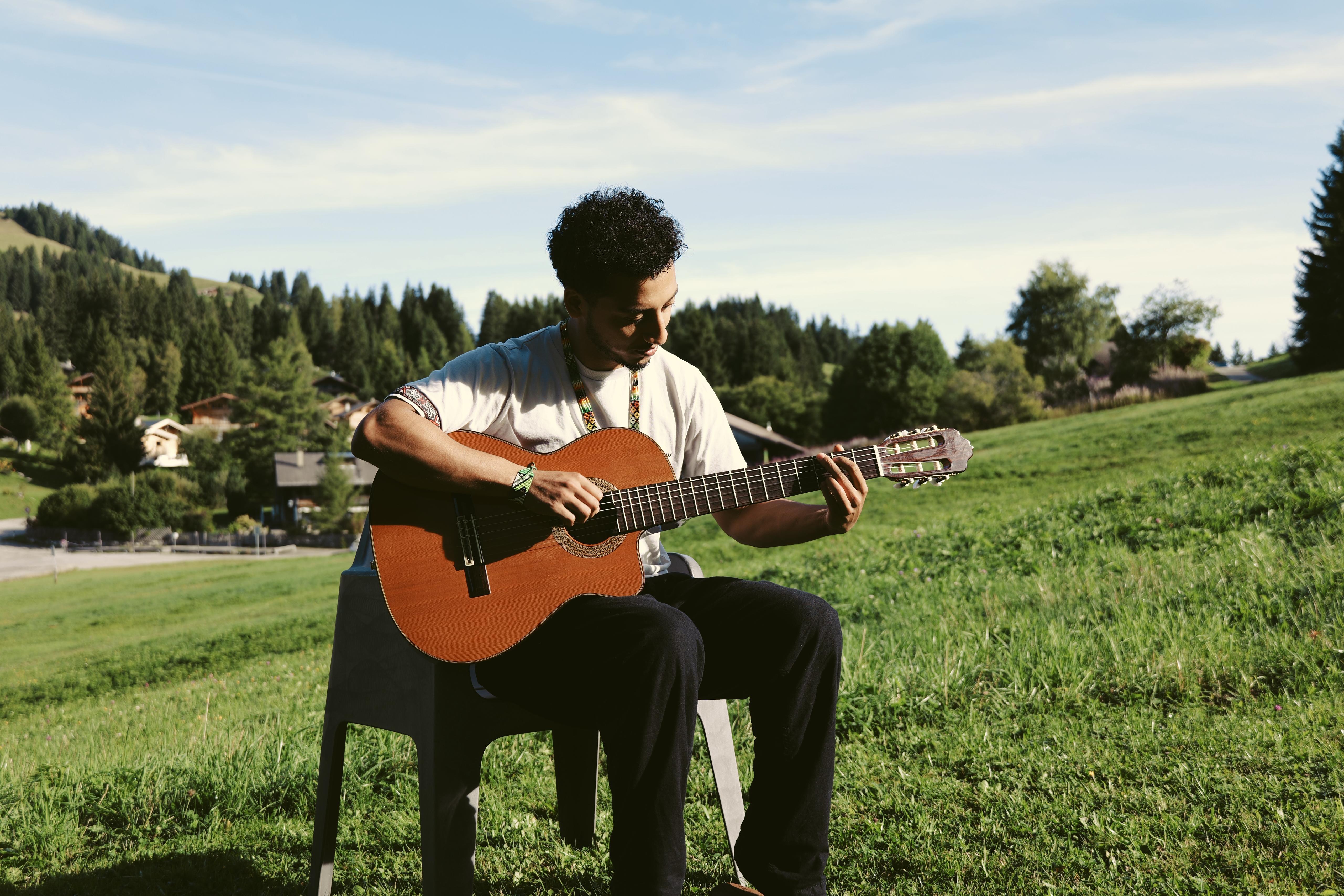 Joran jouant de la guitare dans la prairie